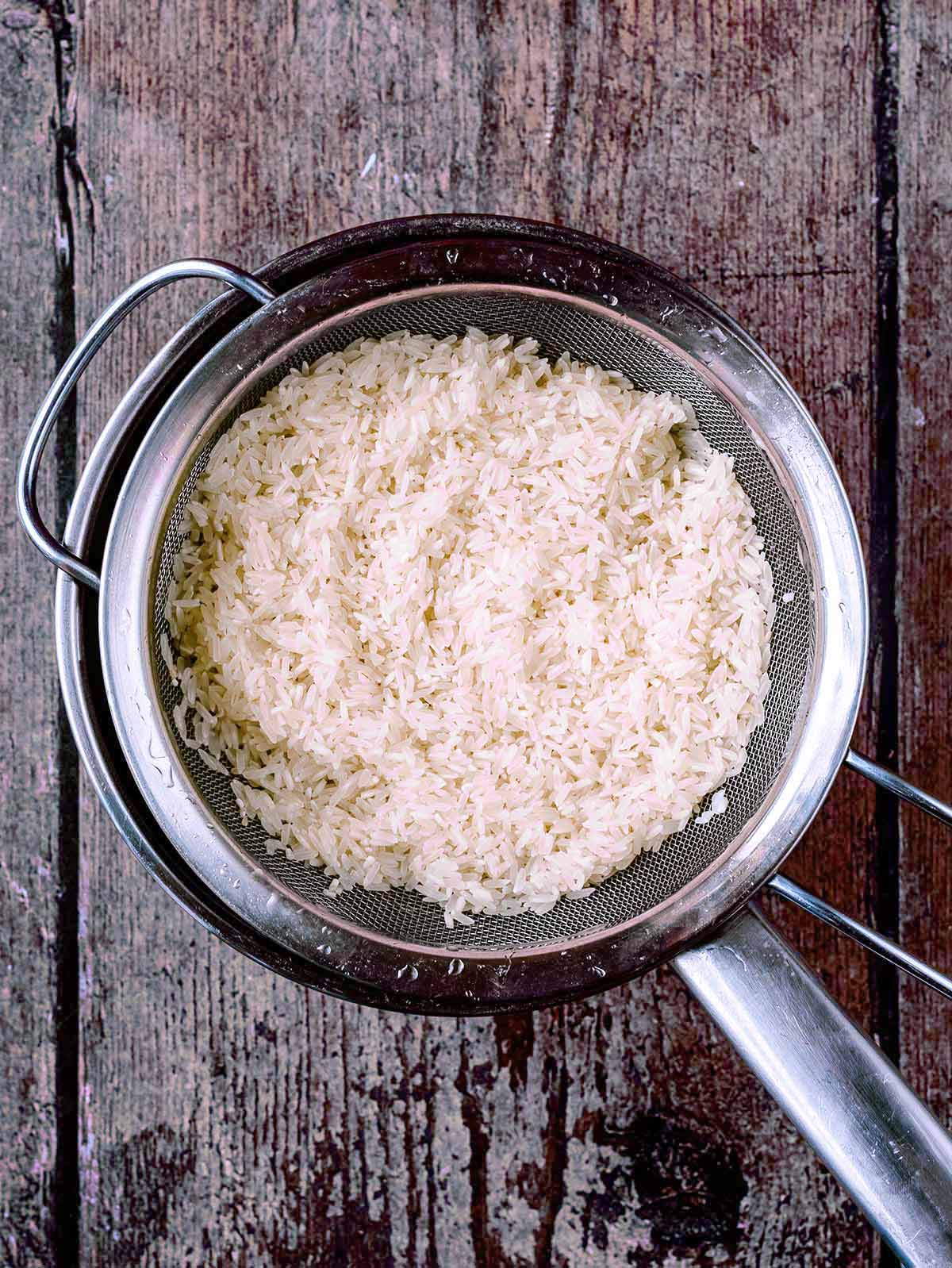 Cooked rice in a sieve.