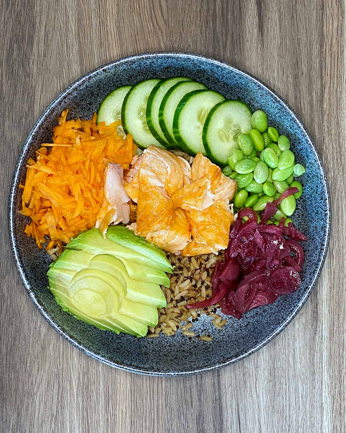 Salmon, cucumber, carrot, onions, beans and avocado added to the bow,.