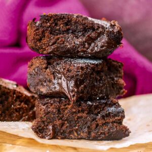 Three air fryer brownies stacked up on a piece of baking paper.