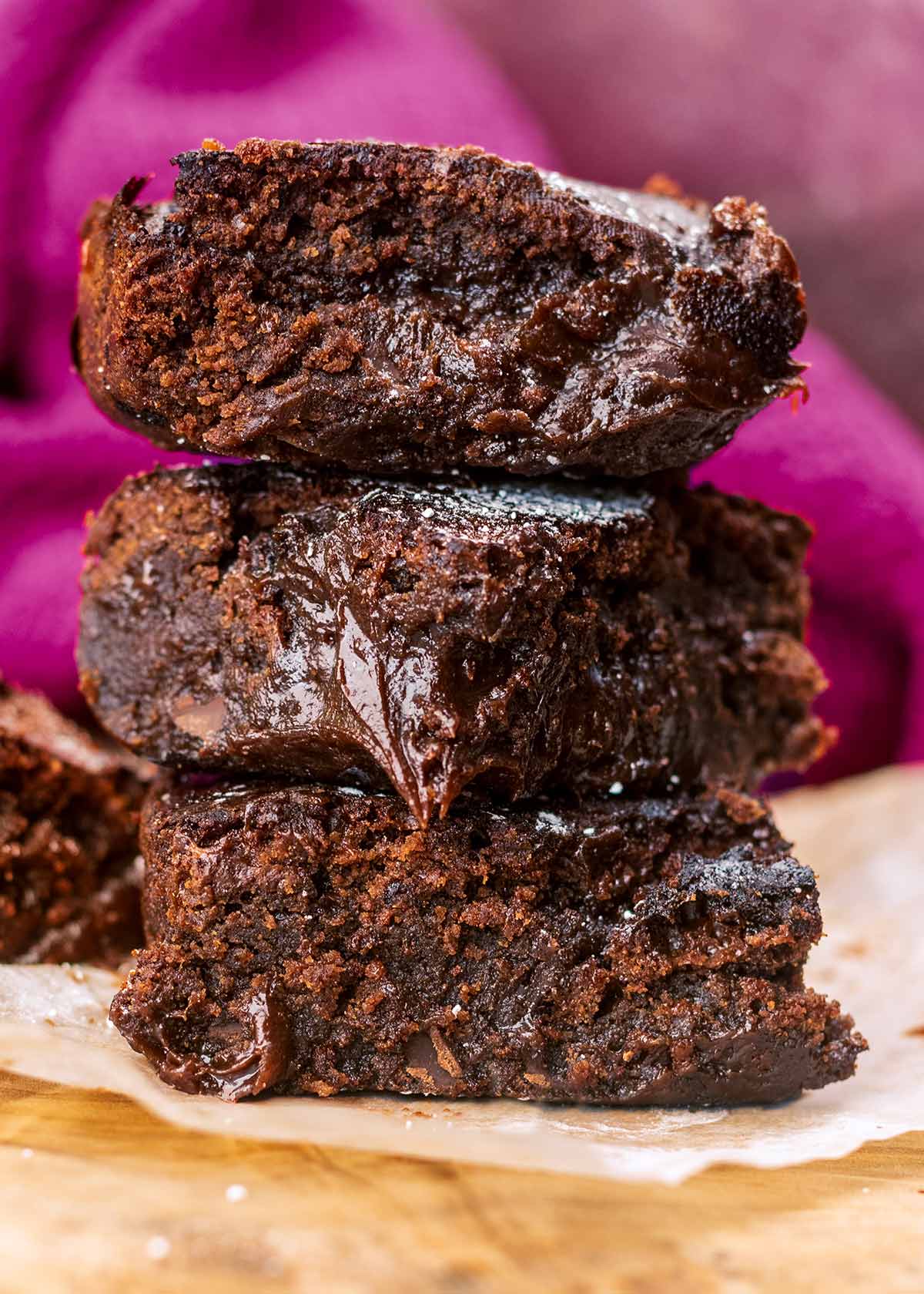 Three chocolate brownies stacked up on top of each other.