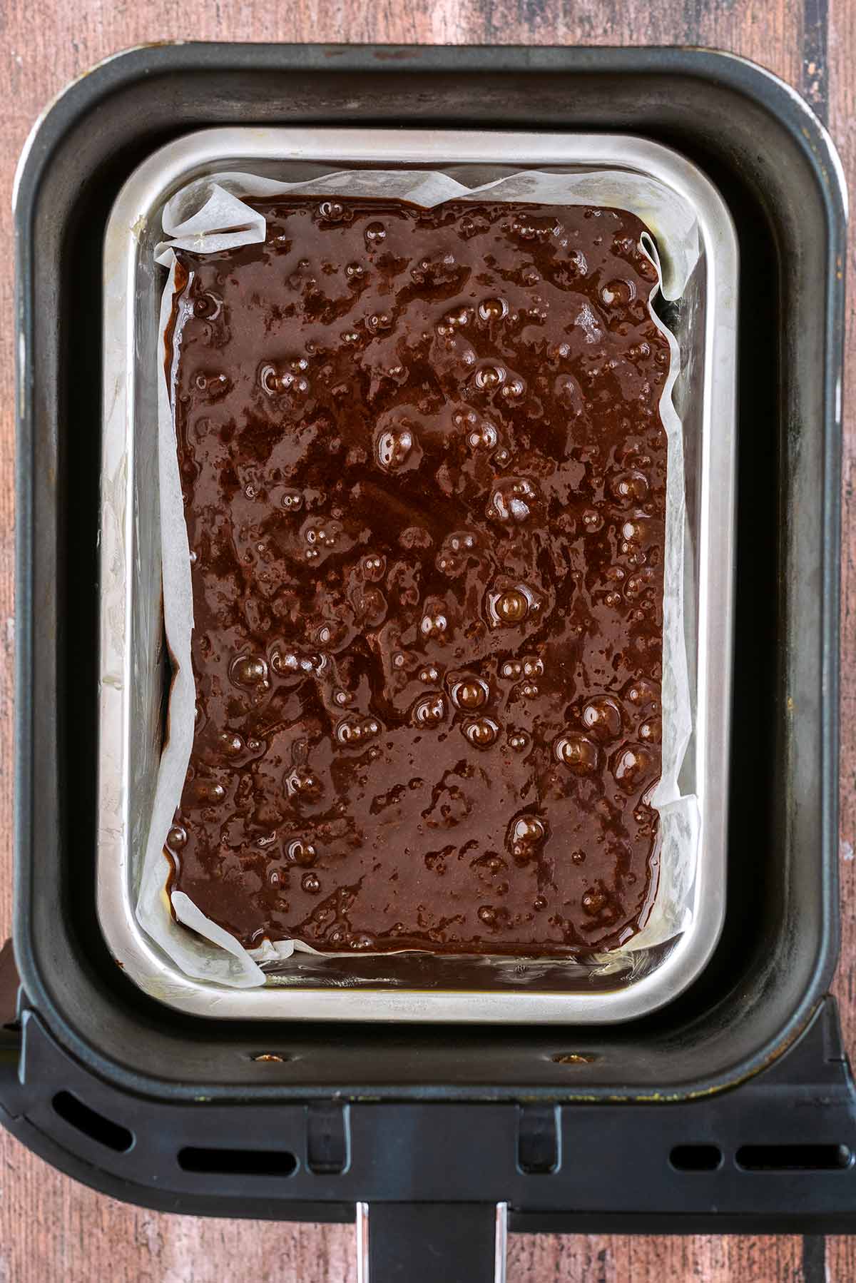 A tin of brownie batter in an air fryer basket.