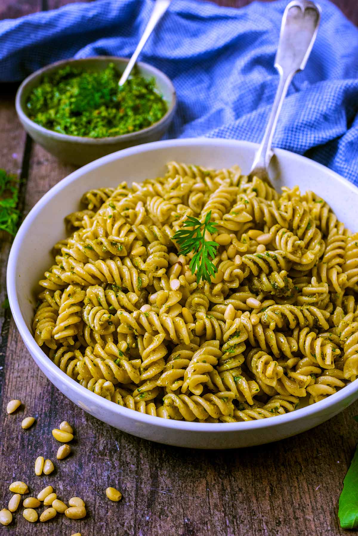 A bowl of cooked fusili pasta mixed with pesto.