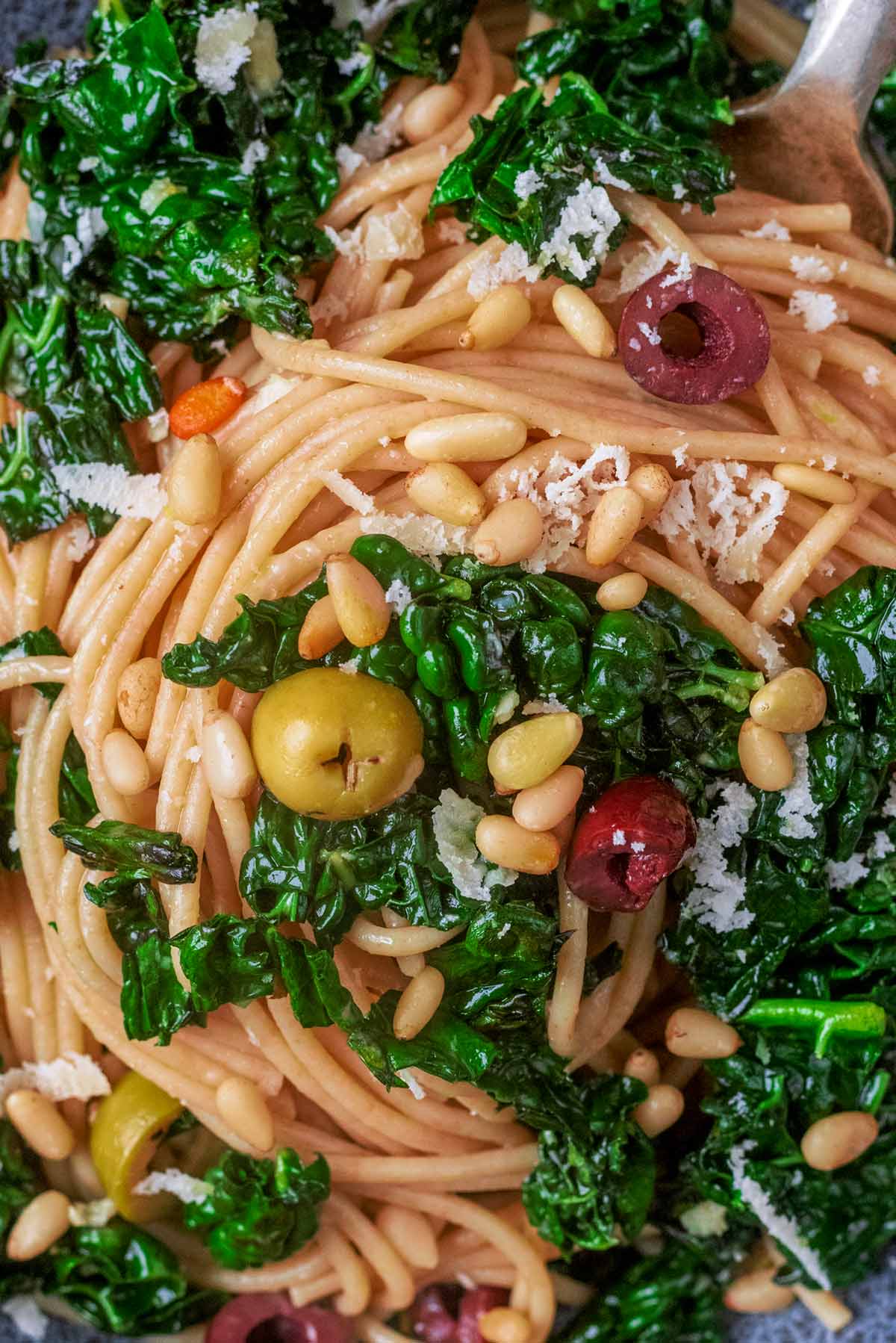 Chopped olives and pine nuts mixed into cooked spaghetti with cavolo nero.