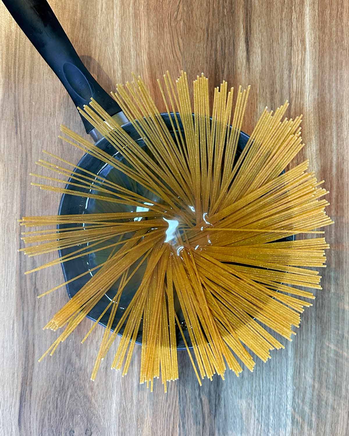 A pan full of uncooked spaghetti.