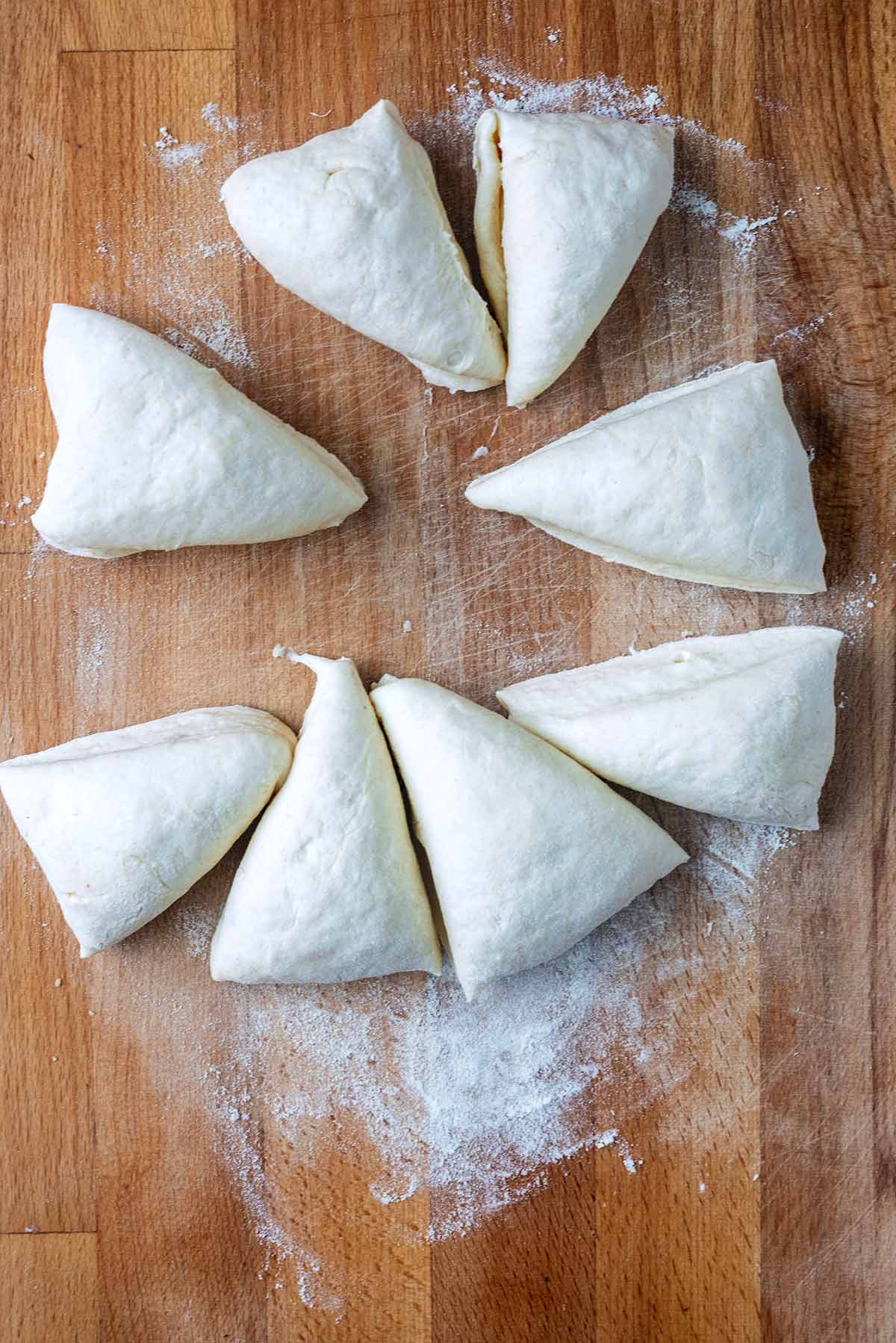 Bread dough cut into eight triangular pieces.
