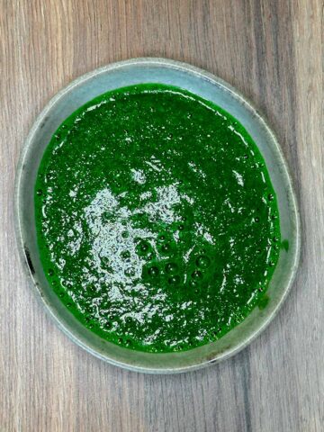 A small bowl full of coriander sauce.
