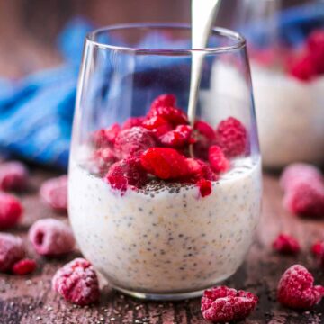 Kefir overnight oats in a glass topped with raspberries.