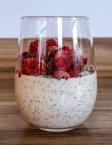 The oat mixture poured into a glass and topped with raspberries.