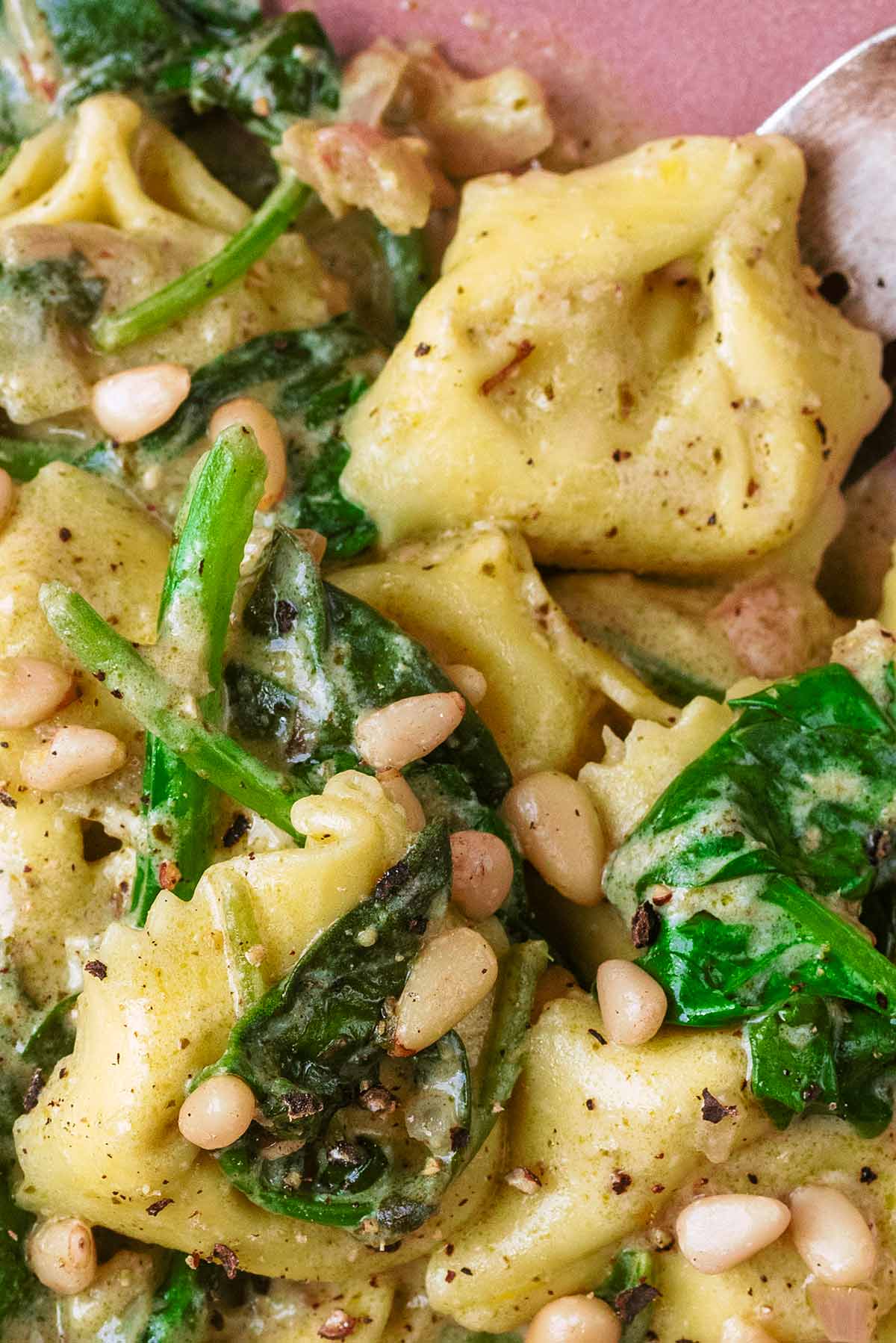 Pine nuts sprinkled over cooked tortellini.