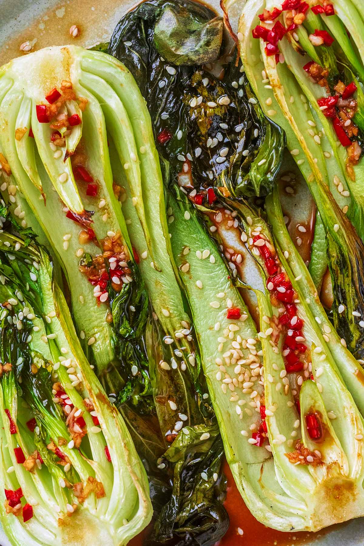Roasted pak choi topped with chopped red chilli and sesame seeds.