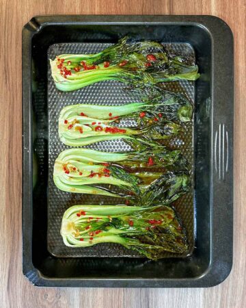 Cooked pak choi in a roasting pan.