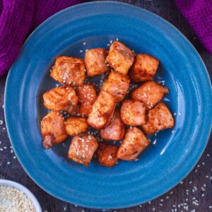 A round blue plate with air fryer salmon bites on it.