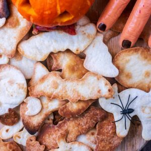 A pile of Halloween Tortilla Chips next to a Jack O'Lantern.