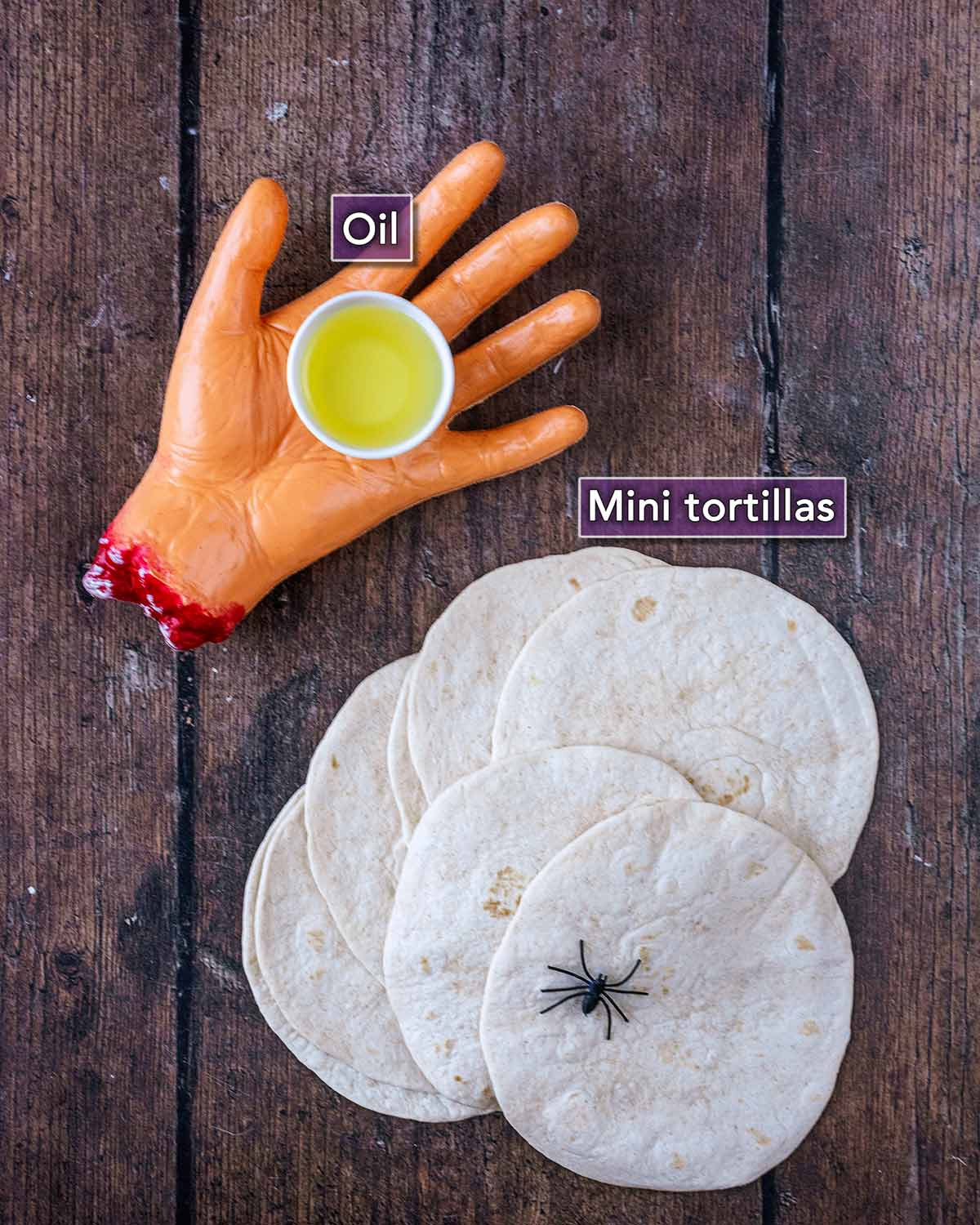 A fake severed hand holding a pot of oil and some flour tortillas with a fake spider.