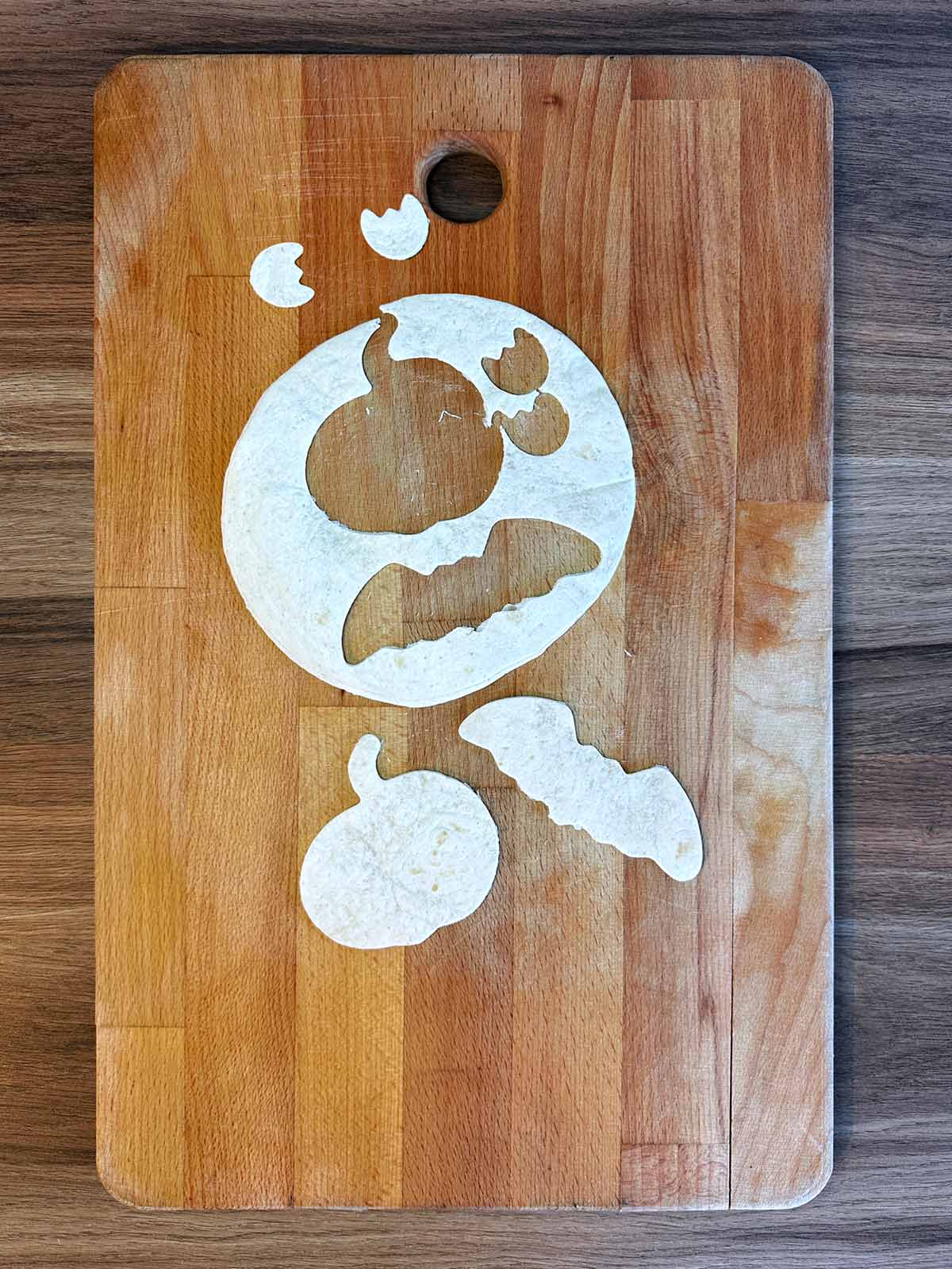 A flour tortilla with halloween shapes cut out of it.