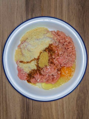 Chicken mince, breadcrumbs, eggs and soy sauce in a bowl.