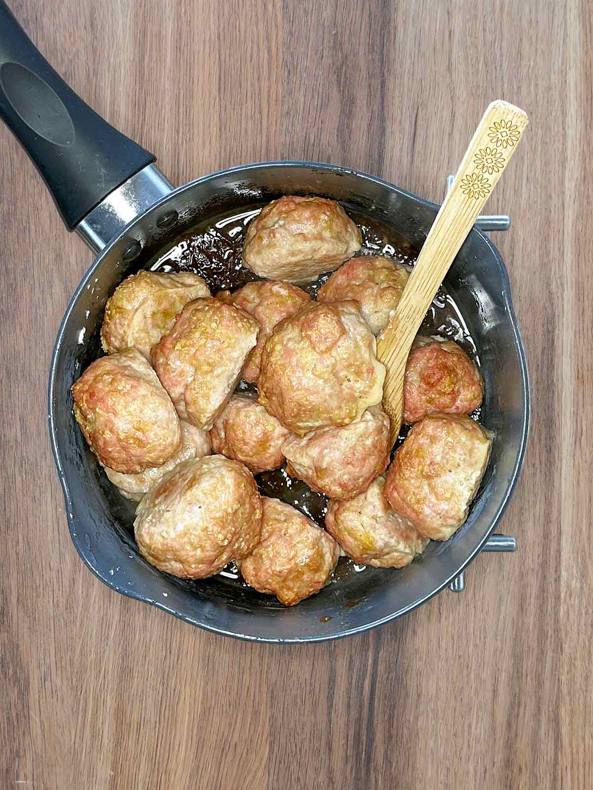 Cooked meatballs in the pan of sauce.