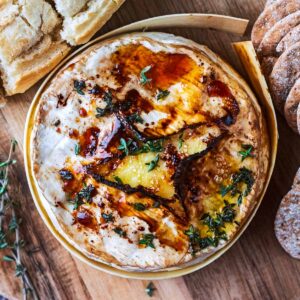 Cooked air fryer camembert on a wooden board.