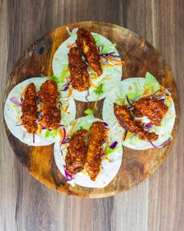 Four mini tacos with lettuce, slaw and coated chicken.