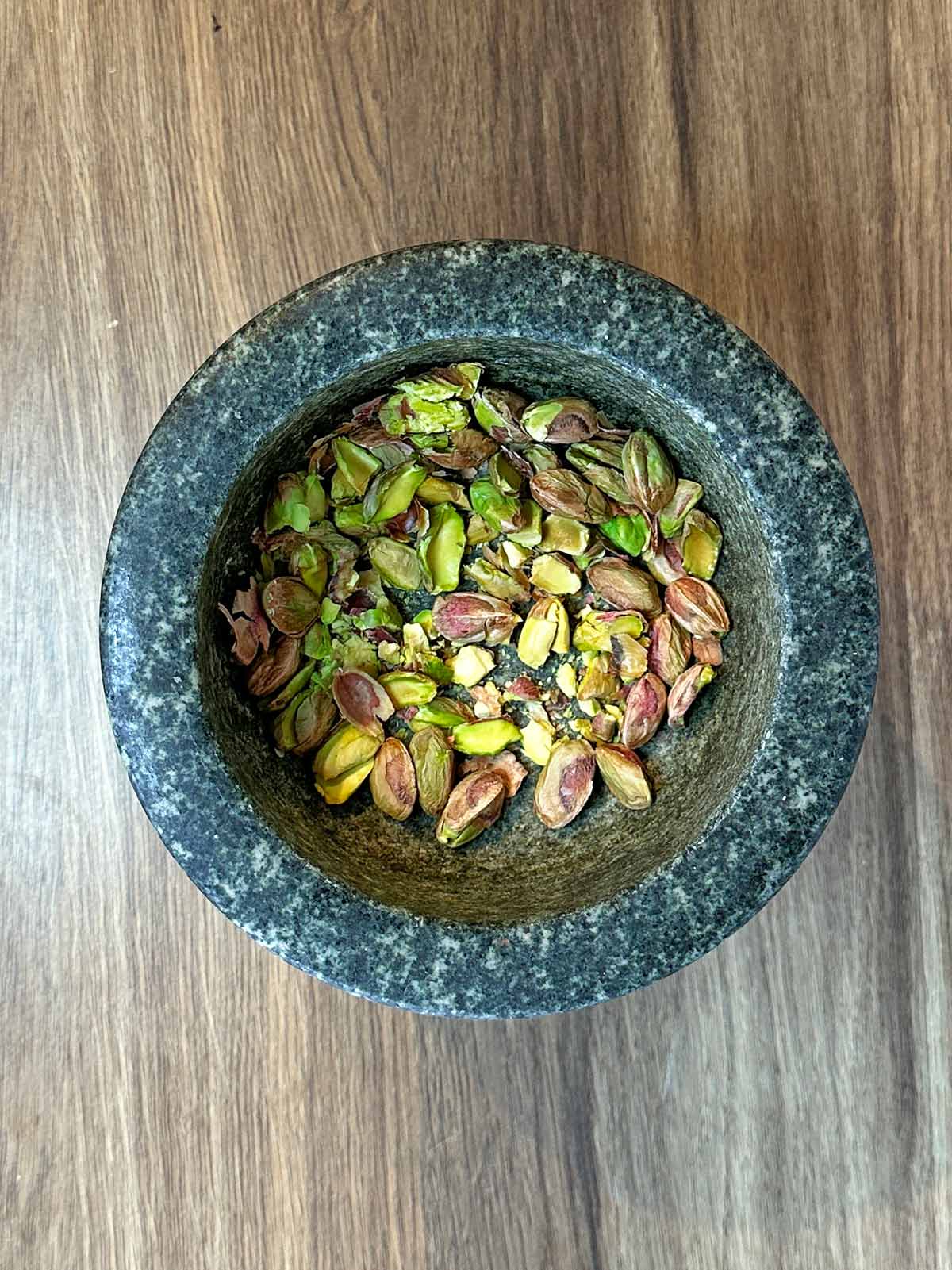 Shelled pistachios in a mortar bowl.