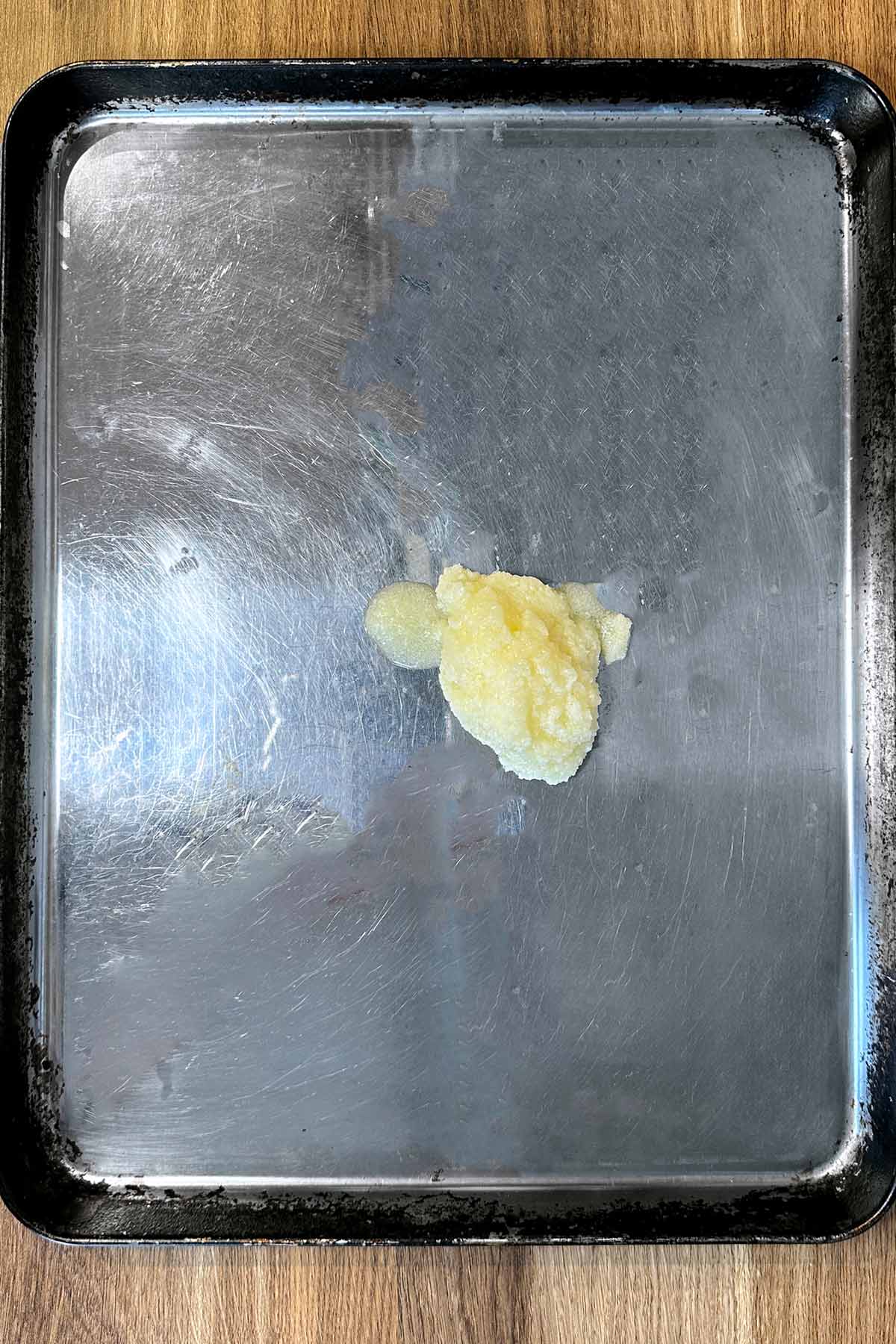 A large dollop of duck fat on a baking tray.