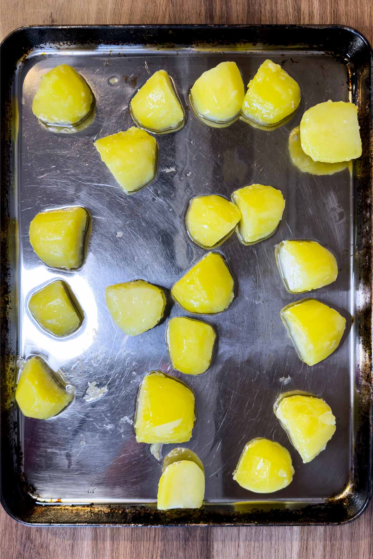 Quartered potatoes added to the hot fat.