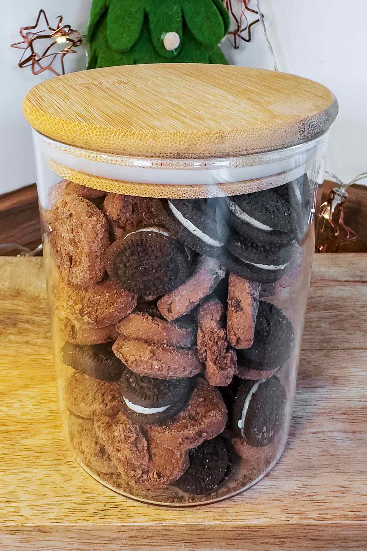 A jar full of mini cookies and mini oreos.