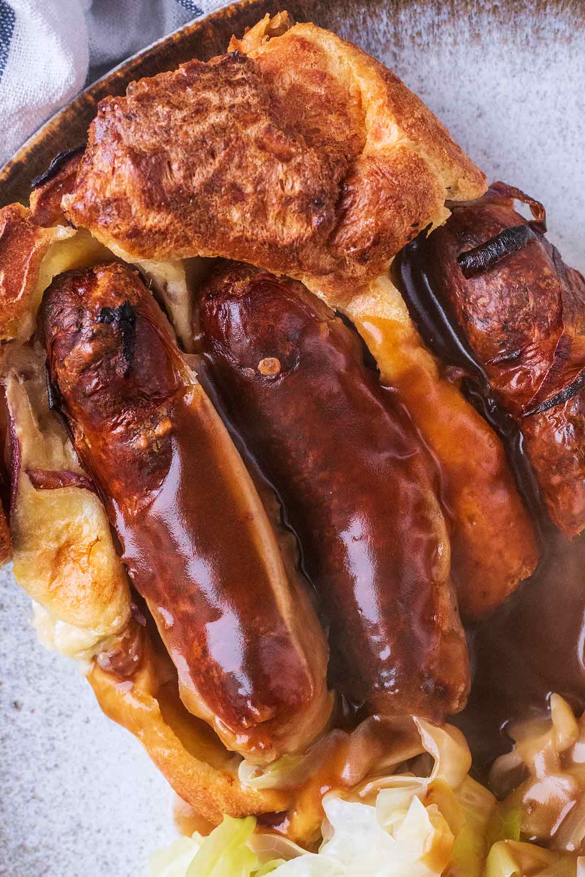 Three cooked sausages encased in Yorkshire pudding.