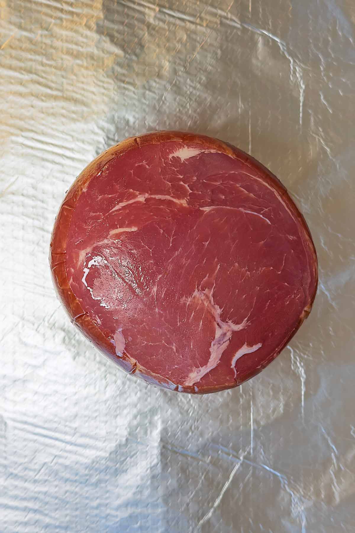 An uncooked gammon joint on a sheet of foil.