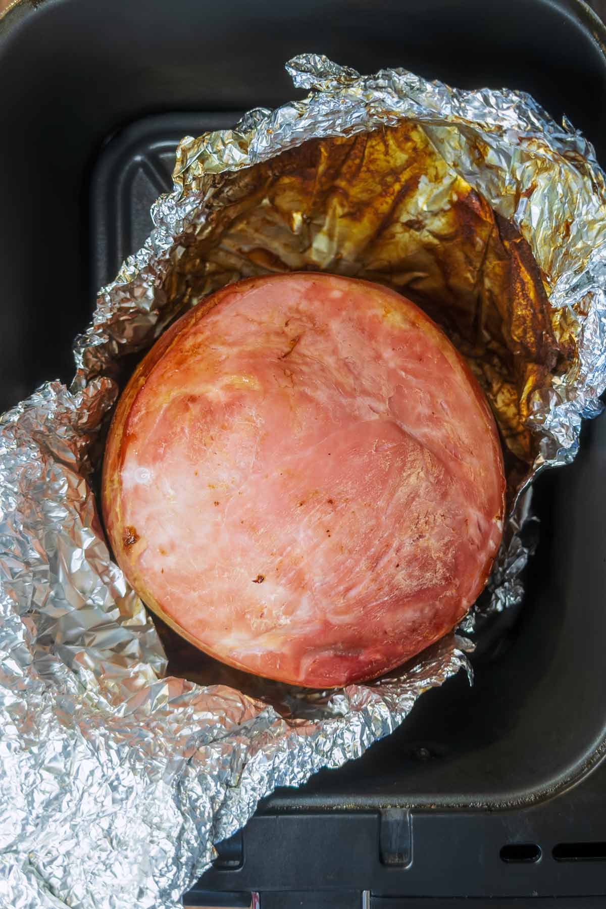 Cooked gammon joint on in open foil.