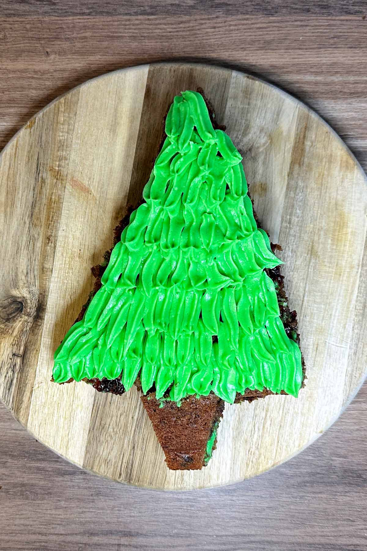 A tree shaped chocolate cake topped with green icing made to look like leaves.