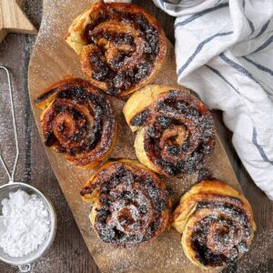 Five mincemeat pinwheels on a wooden serving board.