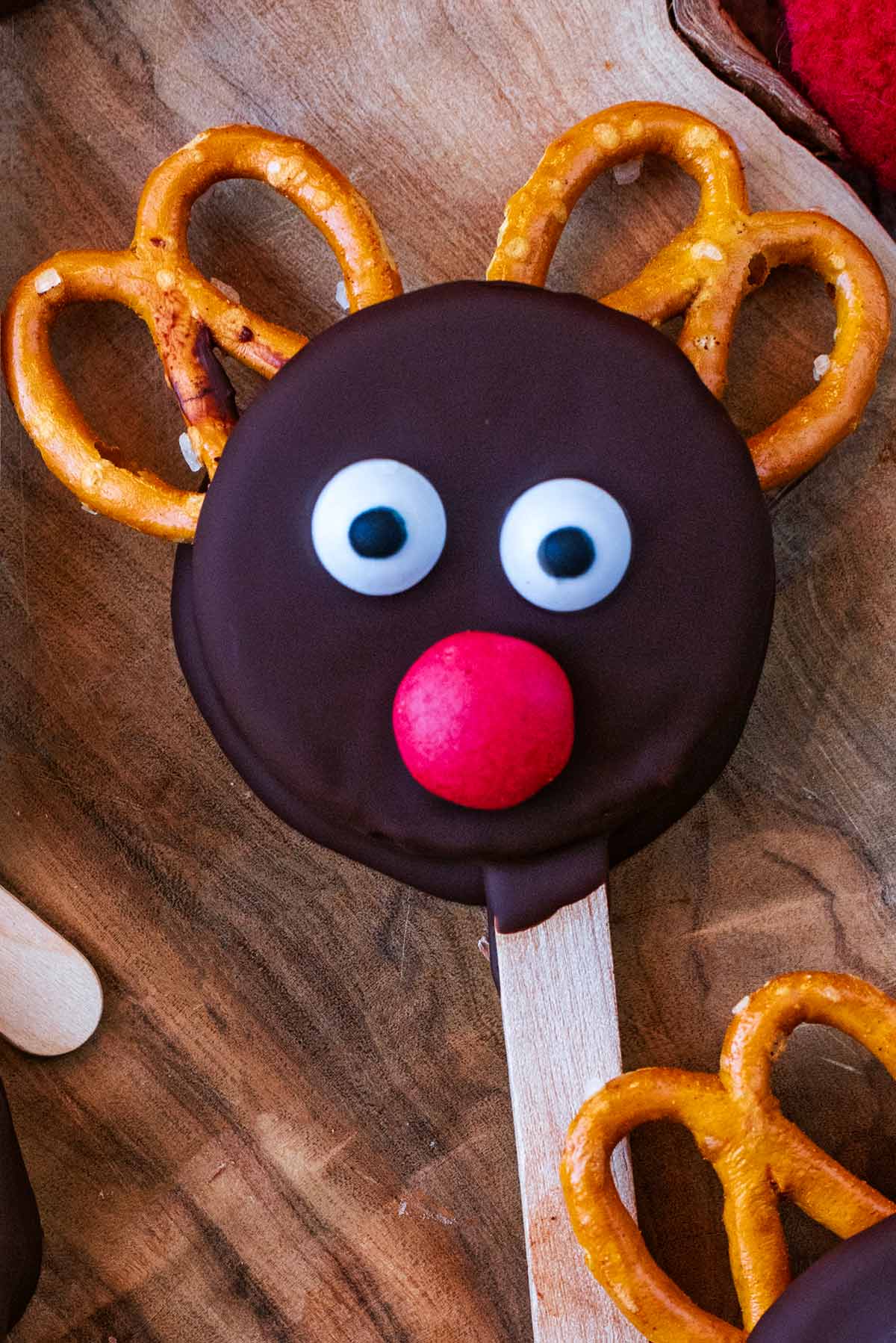 A chocolate coated Oreo with pretzel antlers, a Smartie nose and edible eyes on it.