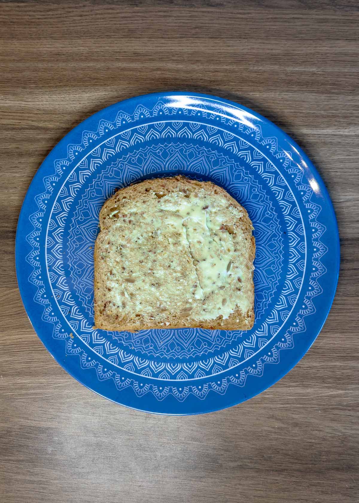 A slice of bread buttered on one side.