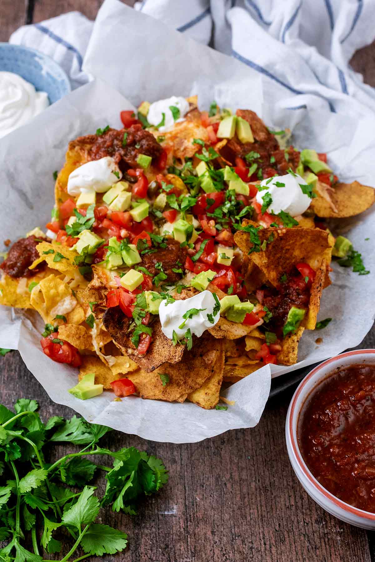 A plate of nachos in front of a striped towel.
