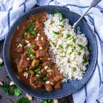 Slow cooker beef massaman curry in a bowl with rice.