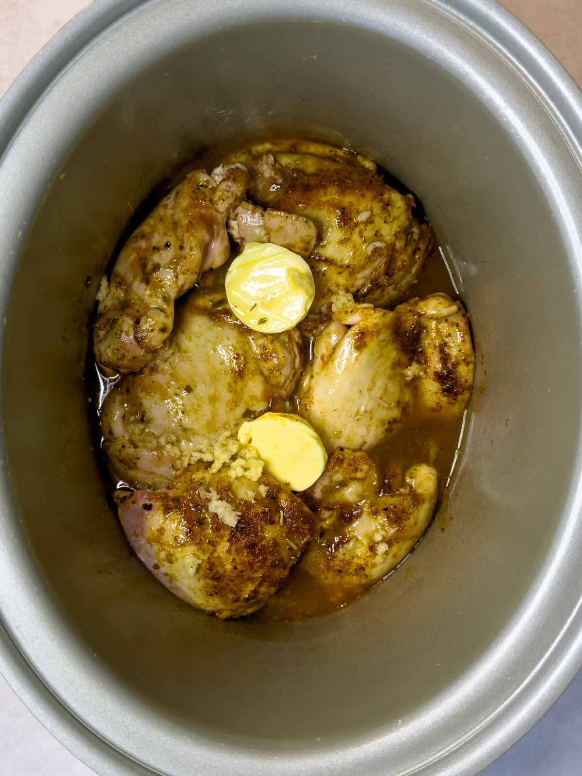Two knobs of butter and stock added to the slow cooker.