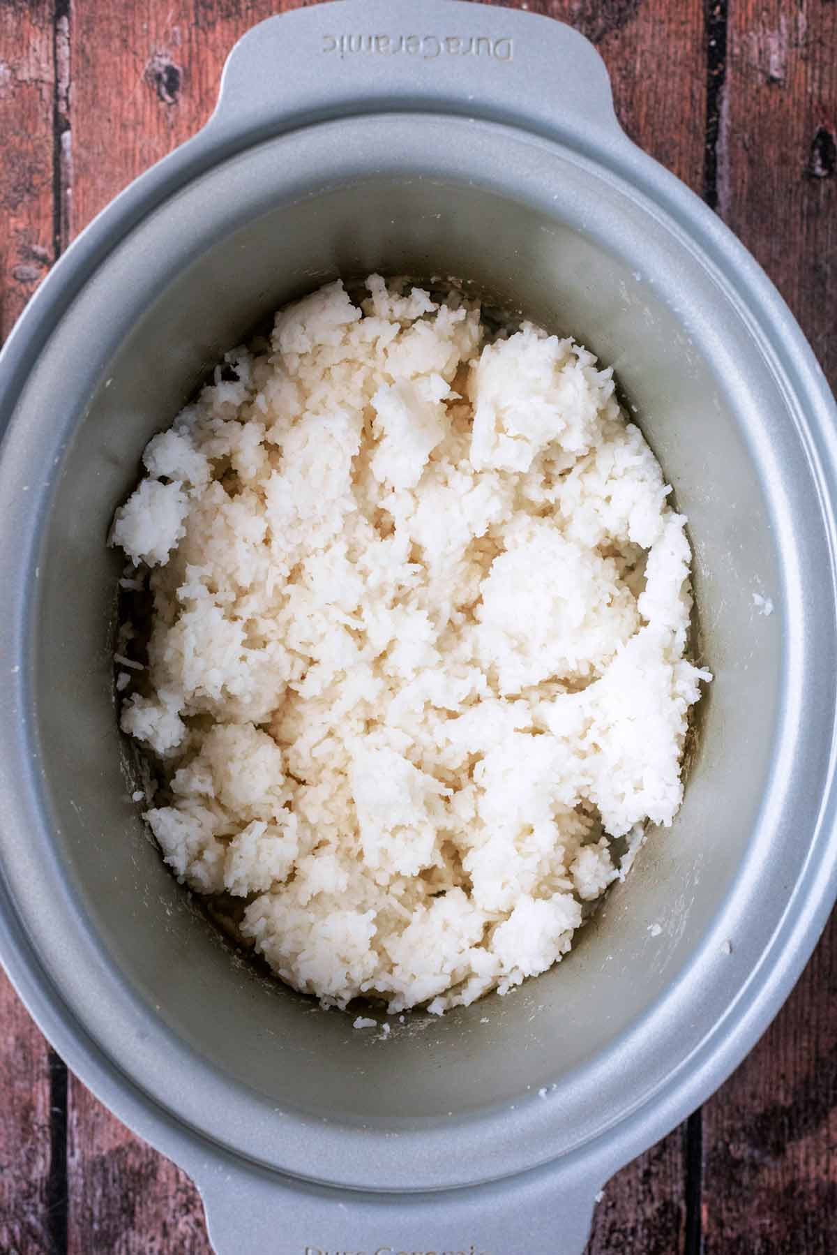 A slow cooker bowl containing cooked white rice.