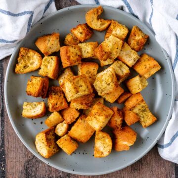 Air fryer croutons on a round grey plate.