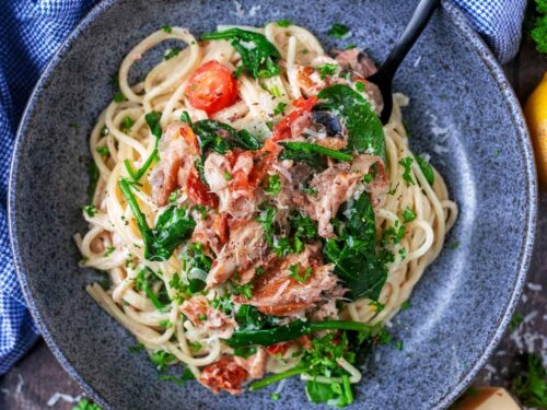 A bowl of mackerel pasta with a black fork in it.