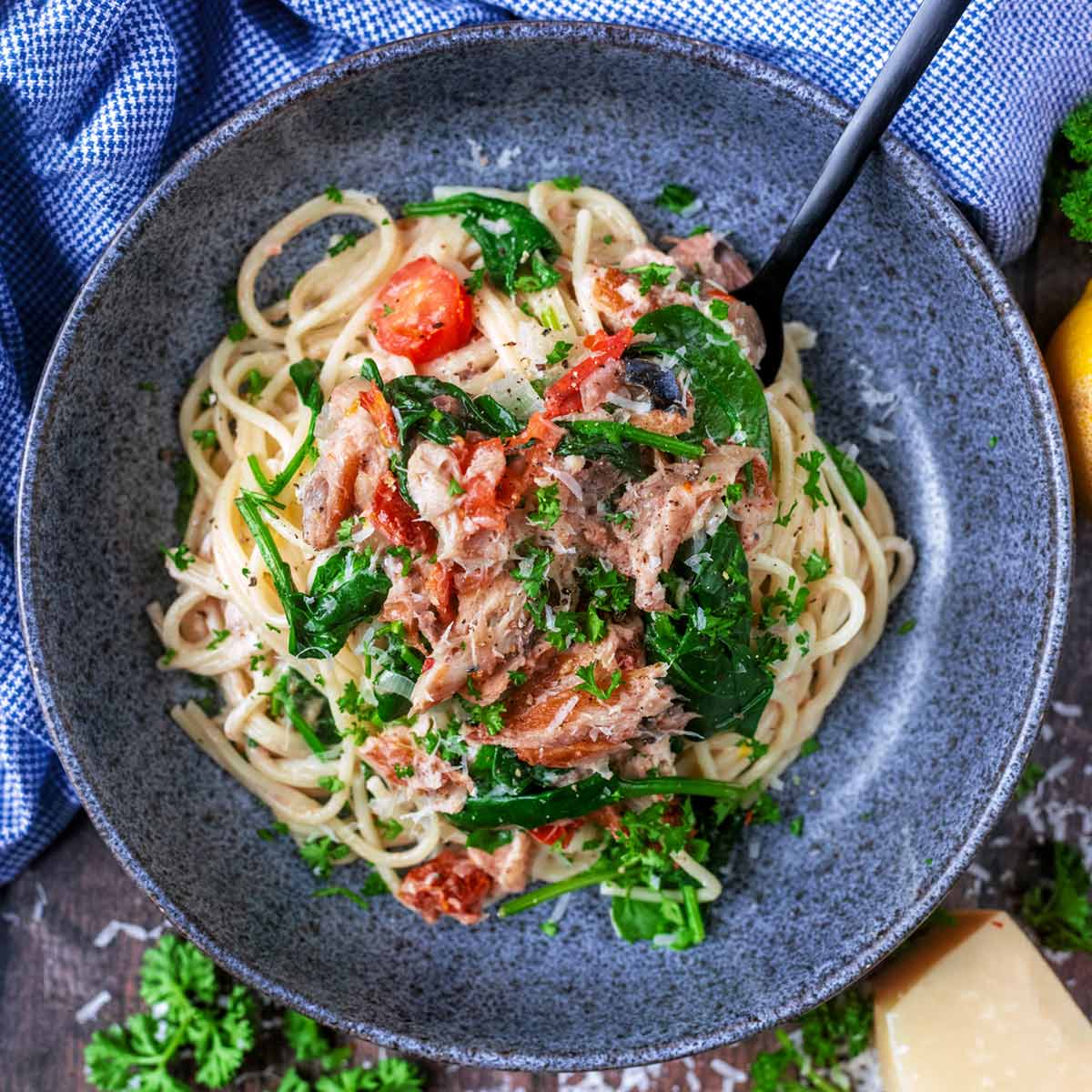 A bowl of mackerel pasta with a black fork in it.
