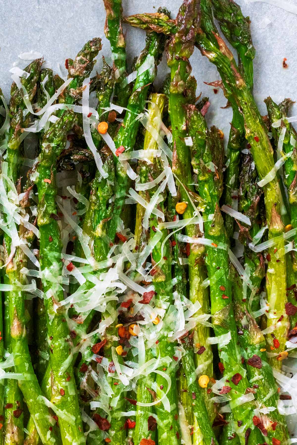 Cooked asparagus spears topped with grated Parmesan and chilli flakes.