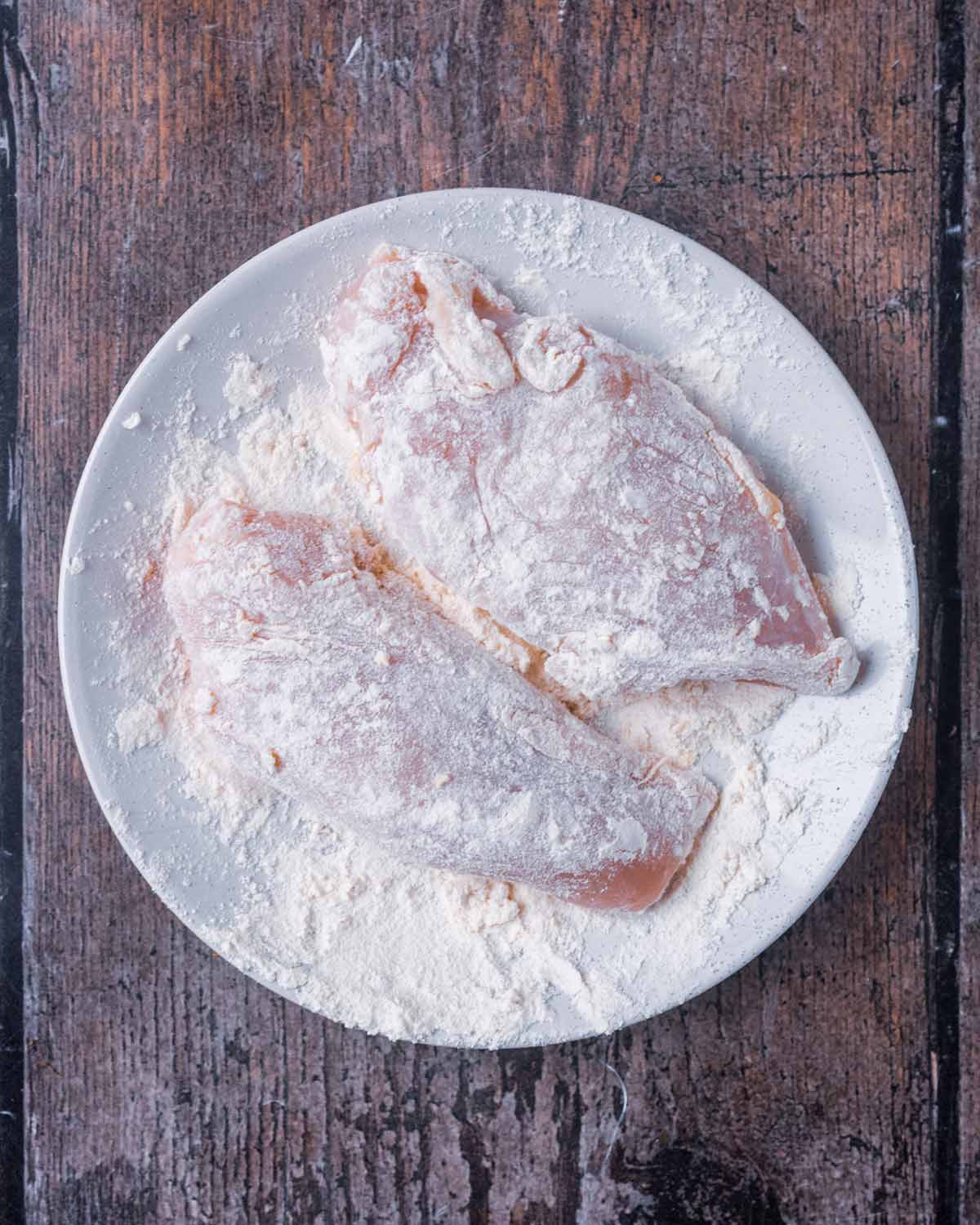 Chicken breasts coated in flour.