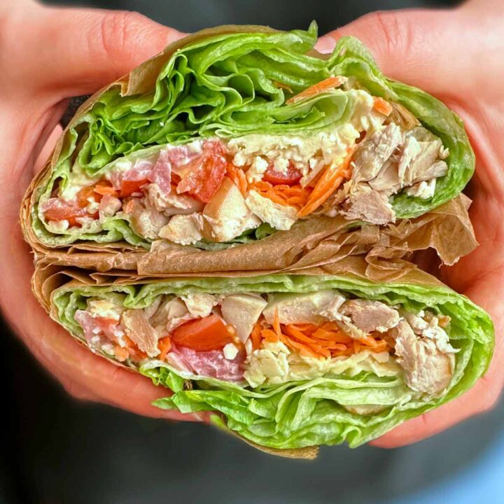 Lettuce wrap sandwich being held up in two hands.