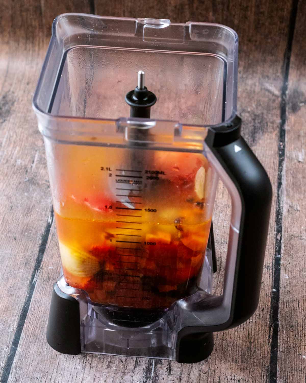 Cooked vegetables and stock in a jug blender.