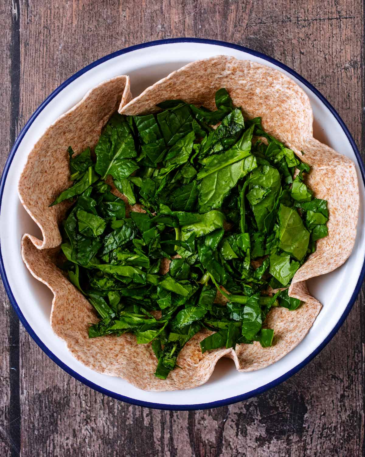 Chopped spinach added to the tortilla.