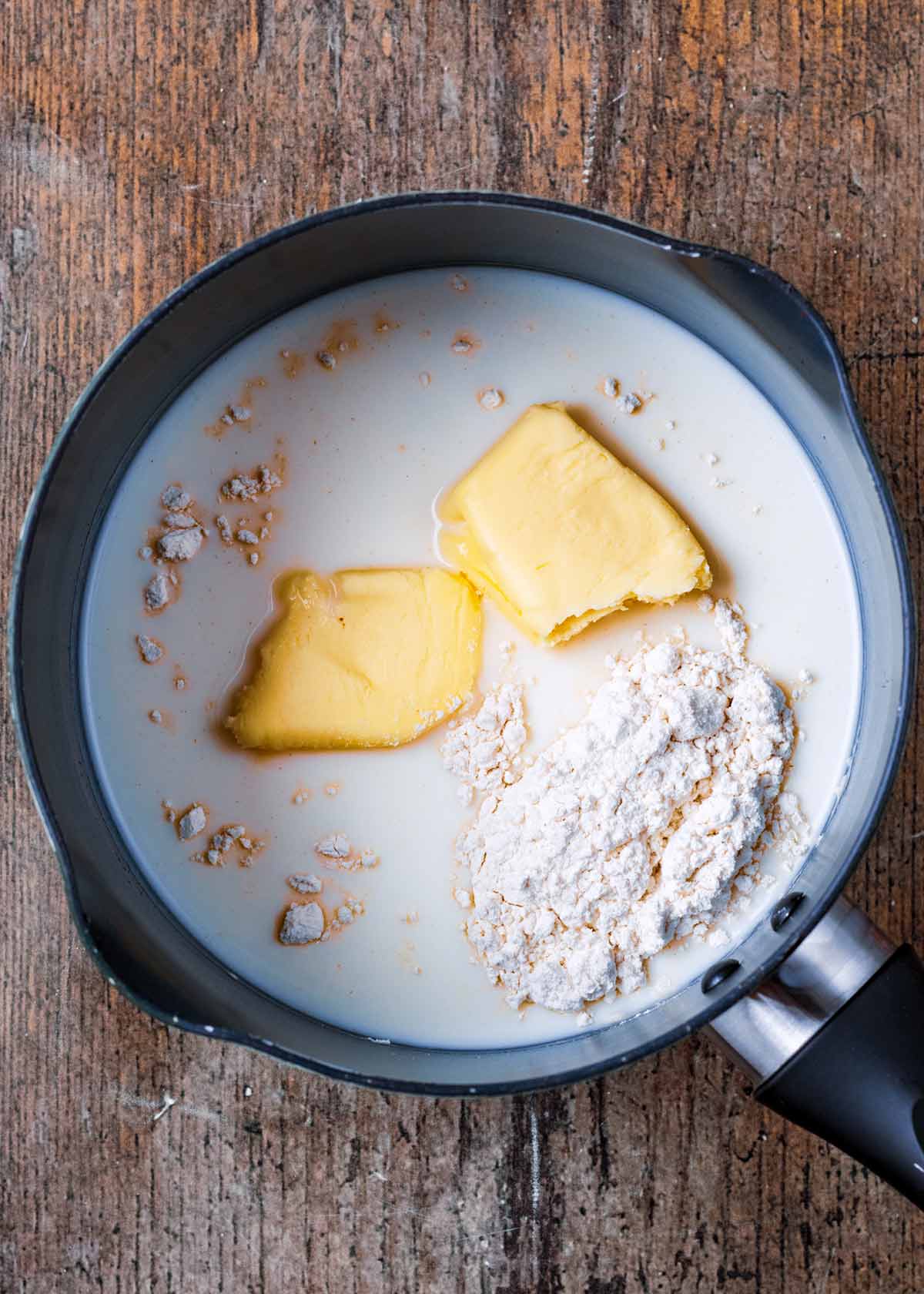 A saucepan containing milk, flour and butter.