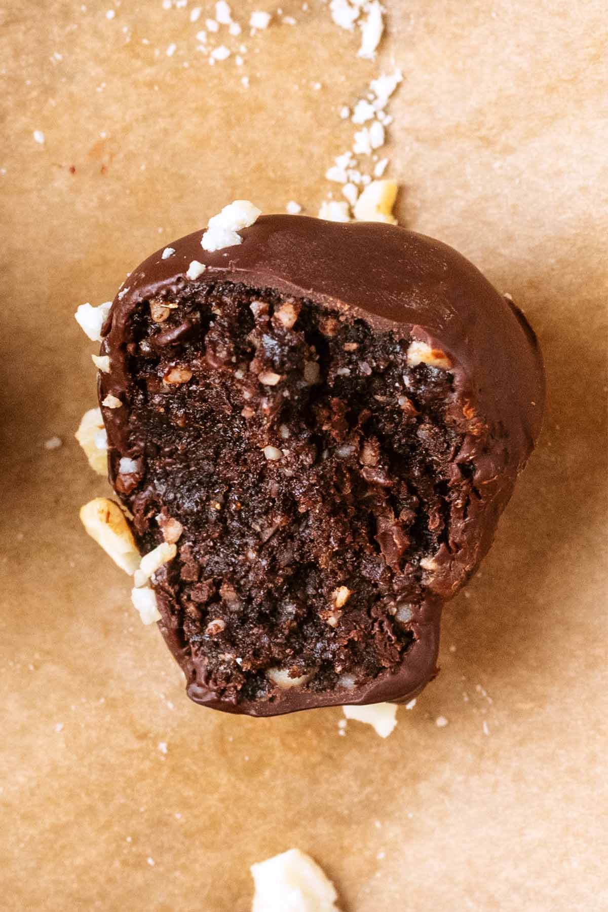 A chocolate covered brownie ball broken open to show the inside.