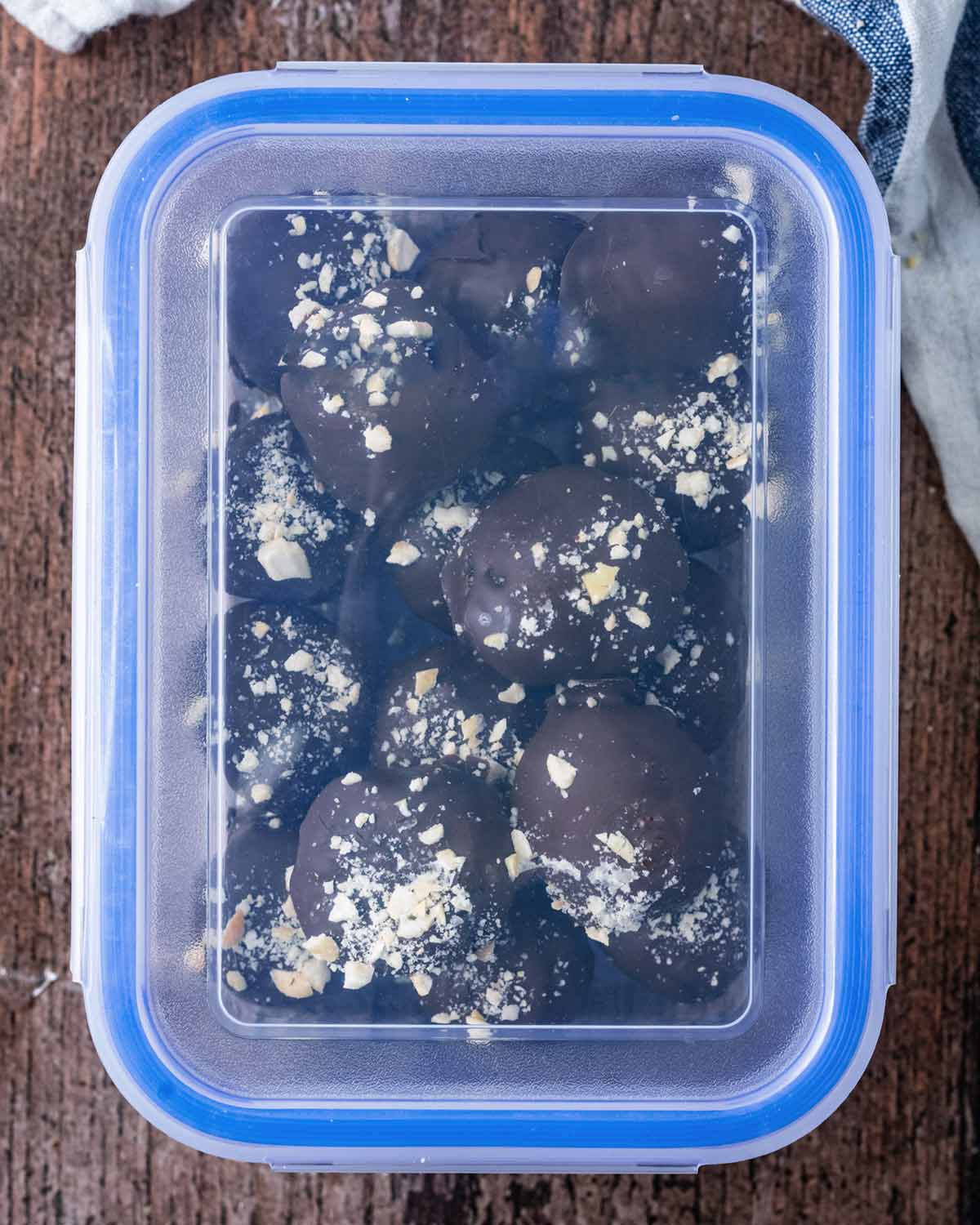 Chocolate brownie balls in an airtight plastic container.