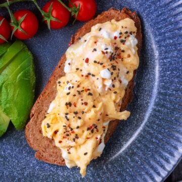 Scrambled eggs with cottage cheese on a slice of toast.